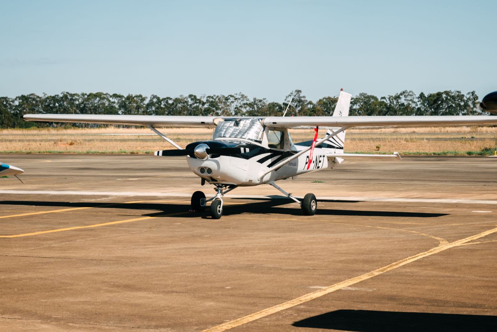 Light aircraft parked at a sunny general-aviation airfield